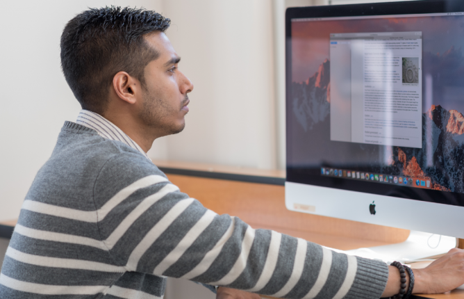 Student reading article on computer