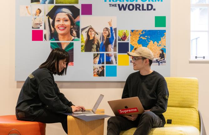Two eople sitting in front of a mural