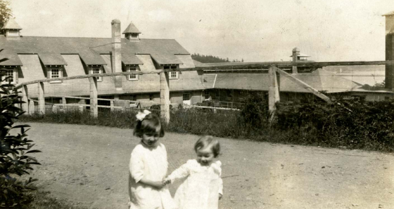 Archival photo of two children in front of building