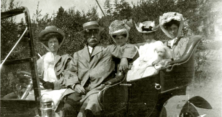 Archival photo of people in old vehicle