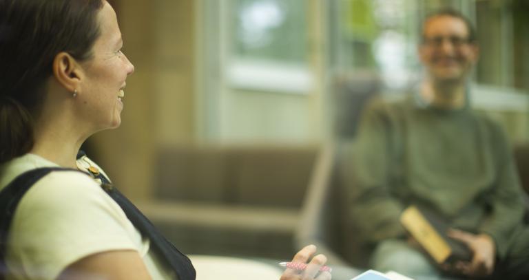 Two people chatting in library