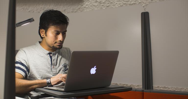 Student typing on macbook